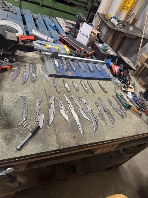 Établi de l'atelier avec plusieurs lames en cours de fabrication
